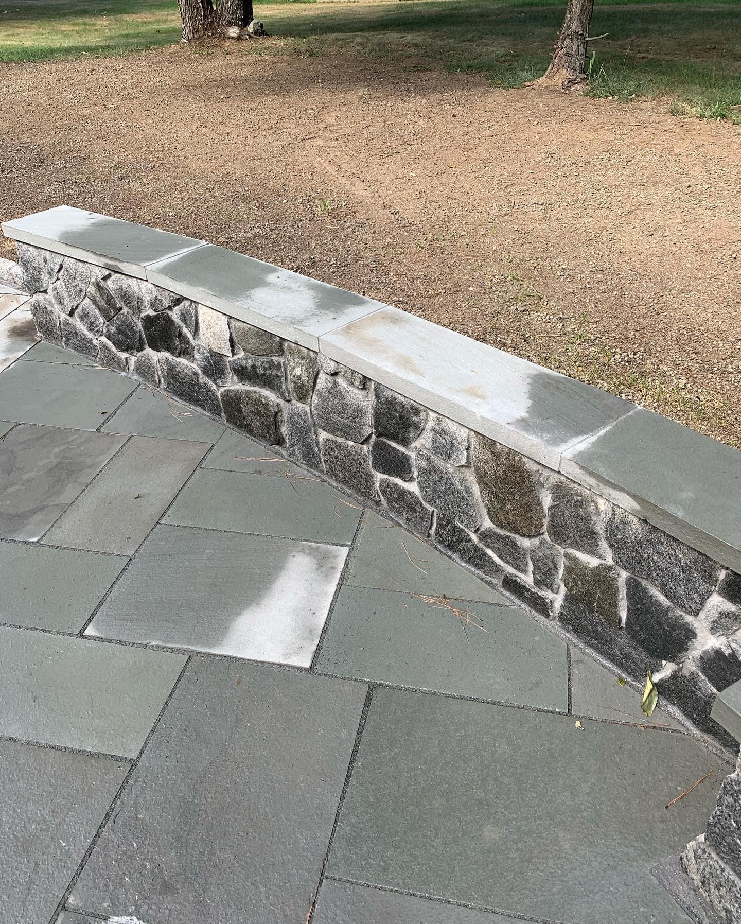 Bluestone patio edged with a fieldstone wall