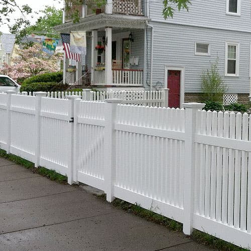 White vinyl privacy fence installed along a property line