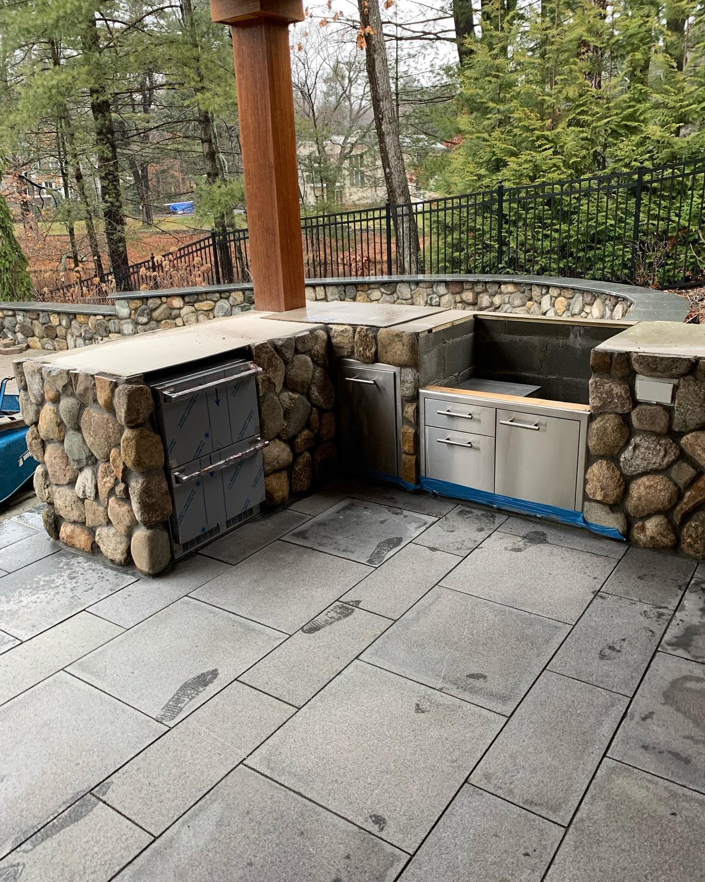 Fieldstone outdoor kitchen with stainless drawers and bluestone patio