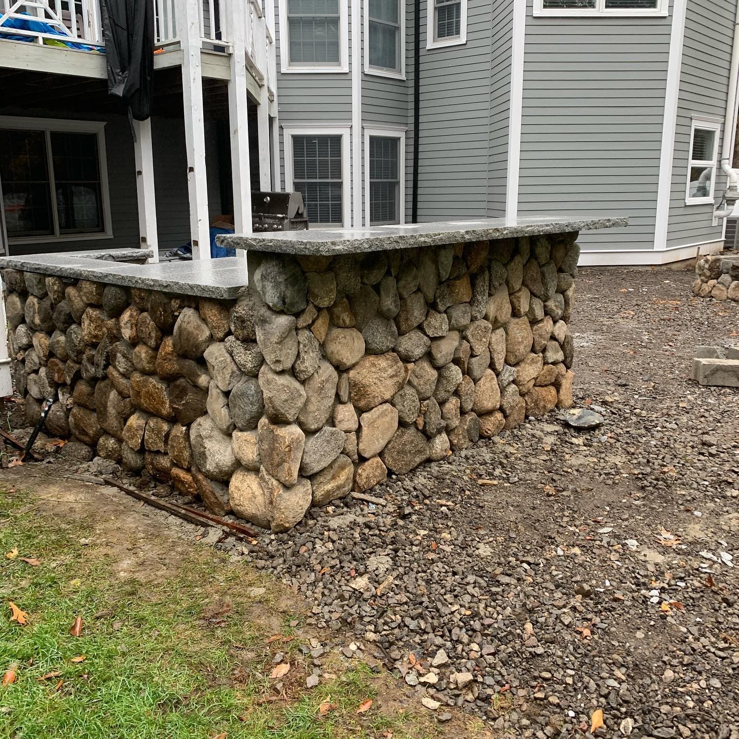 Fieldstone bar with granite top before the patio around it is laid