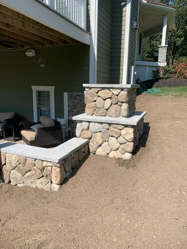 Fieldstone fireplace and seat wall under a deck