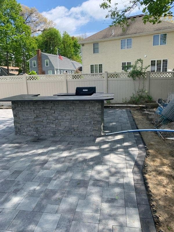 Stacked-stone grill island on a new paver patio