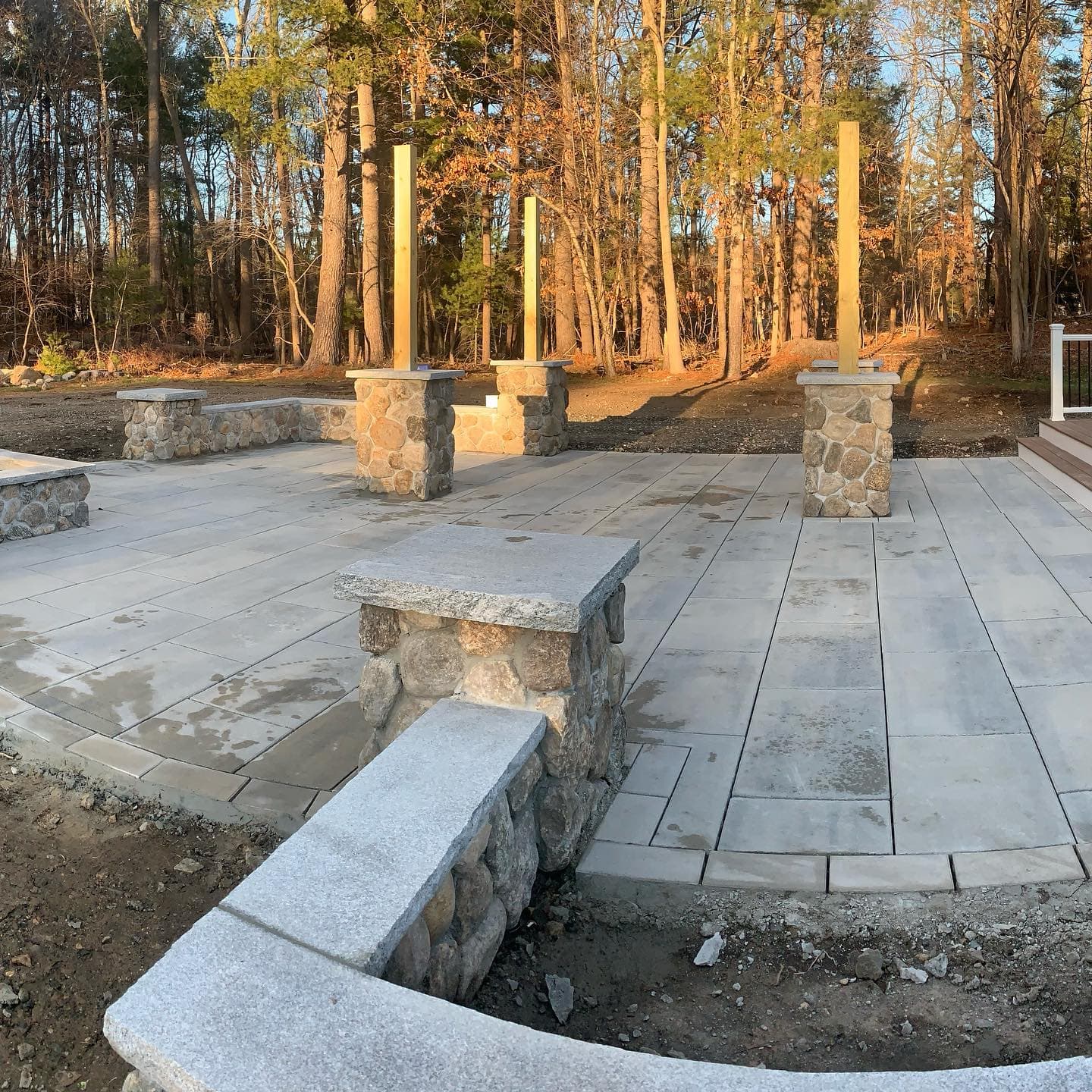 Stone patio with granite seat walls and pillars at sunset