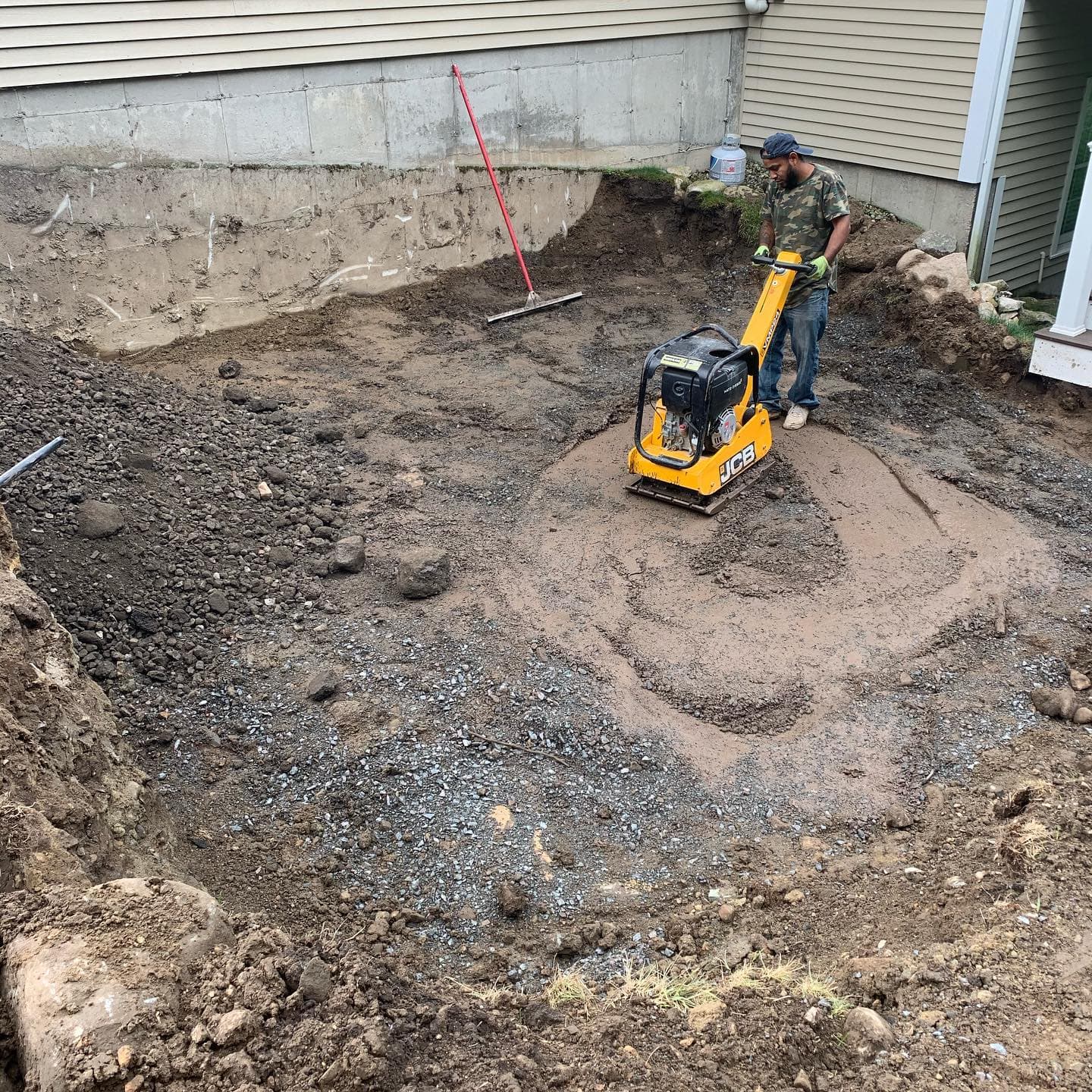 Plate compactor compacting the crushed-stone base for a patio