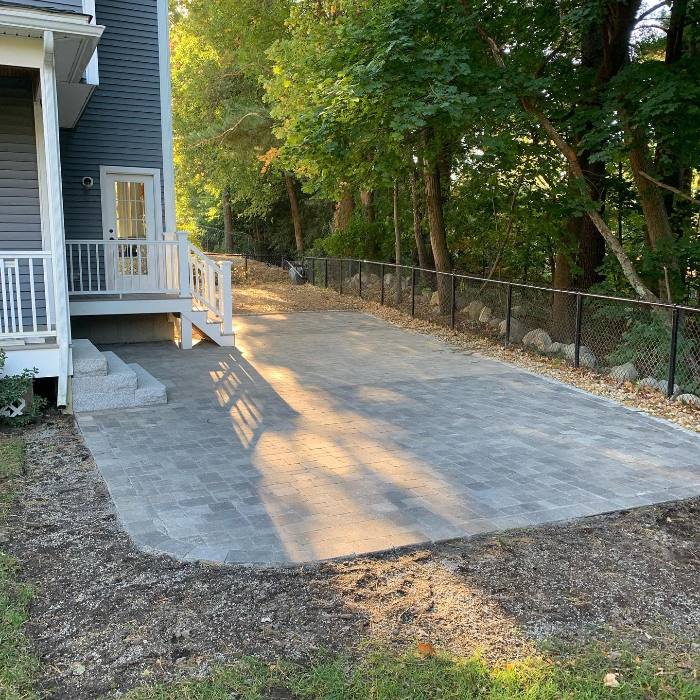 Large paver patio at the foot of deck stairs