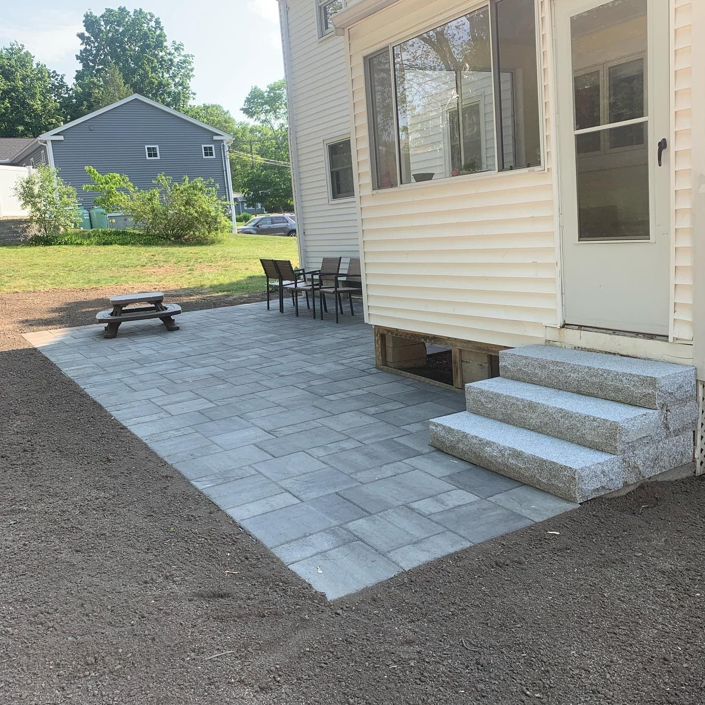 Paver patio with granite steps up to the house