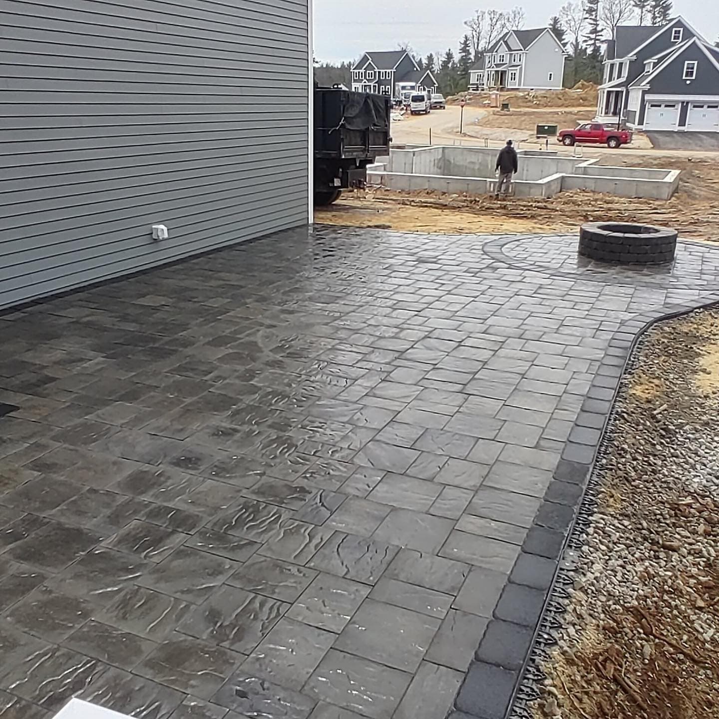 New-construction paver patio with a charcoal border