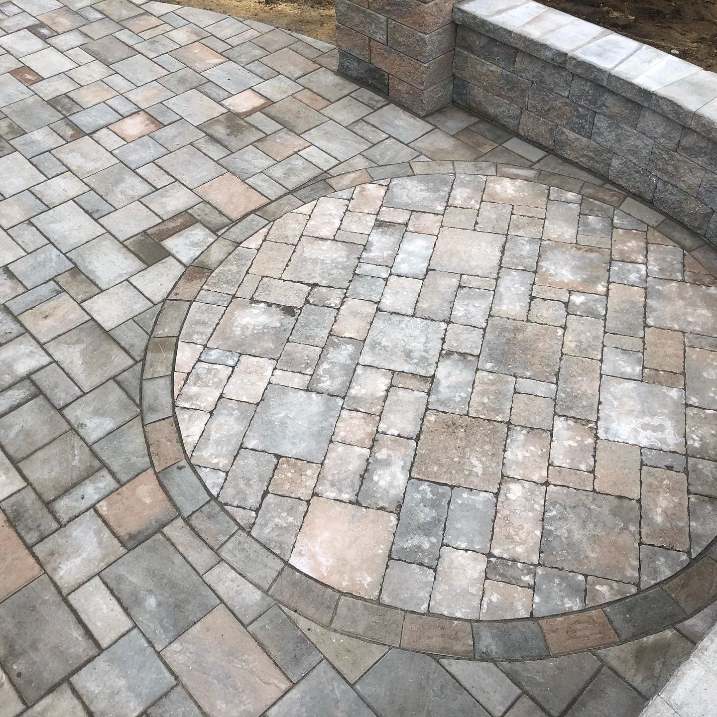 Gray paver patio with a circular inlay