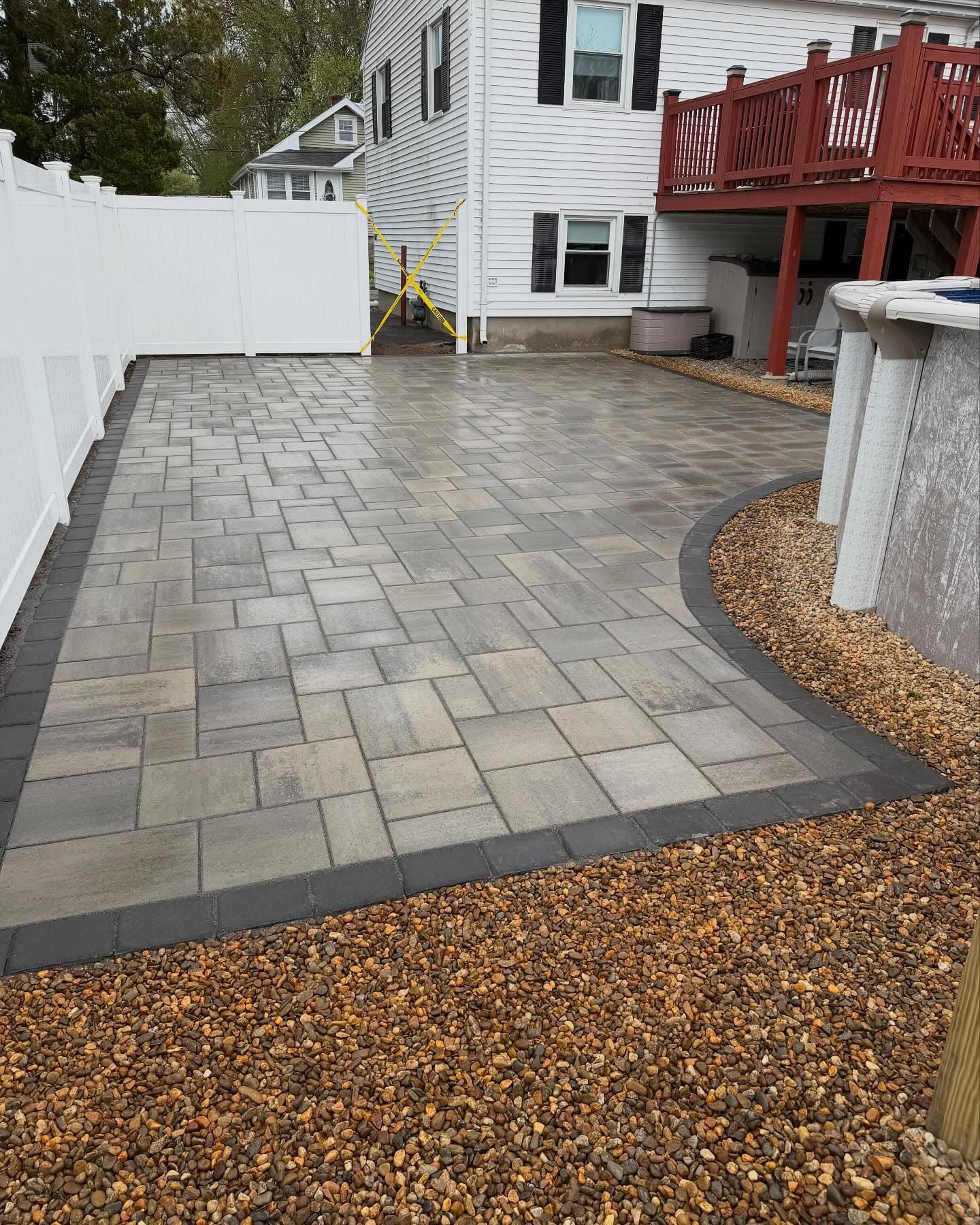 Side-yard paver patio edged with pea stone