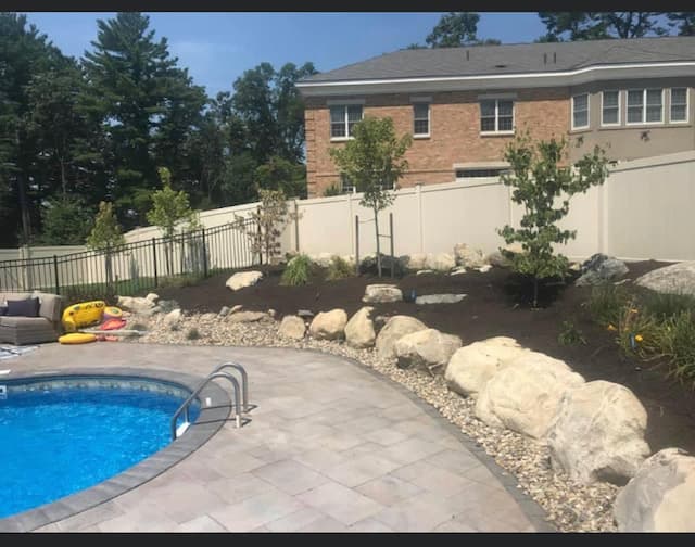 Pool edged with boulders, river stone and new plantings