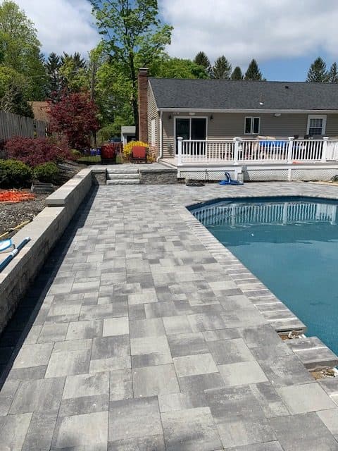 Long paver deck along the side of a pool