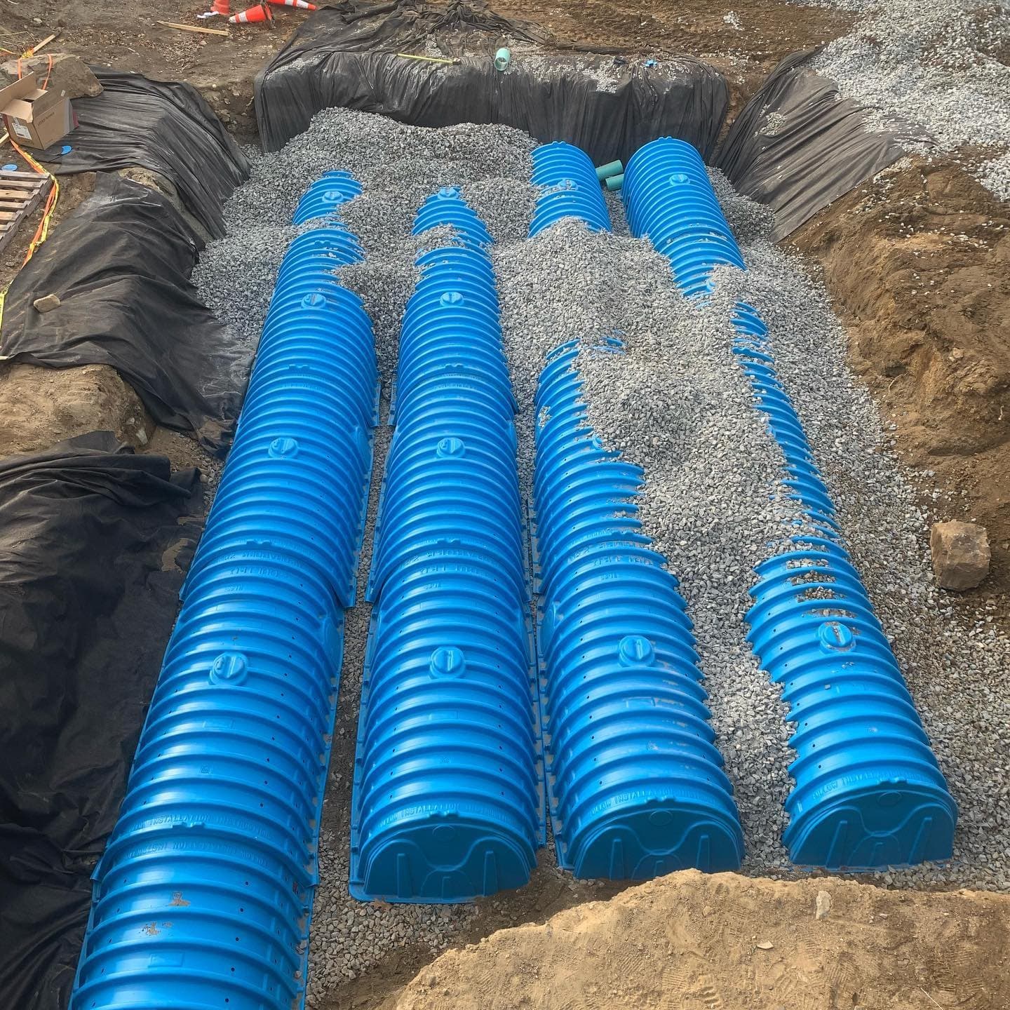 Rows of blue infiltration chambers bedded in crushed stone
