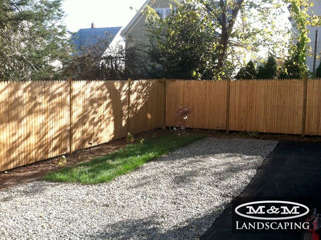 Wood privacy fence around a gravel yard