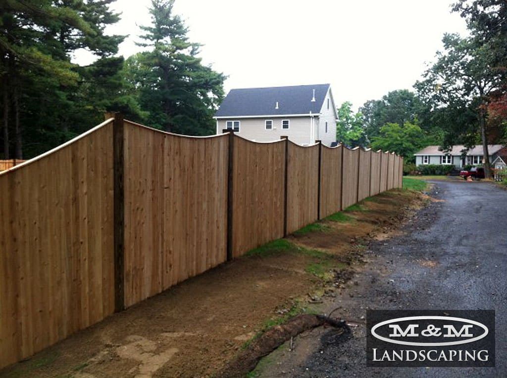Long wood board fence along a driveway