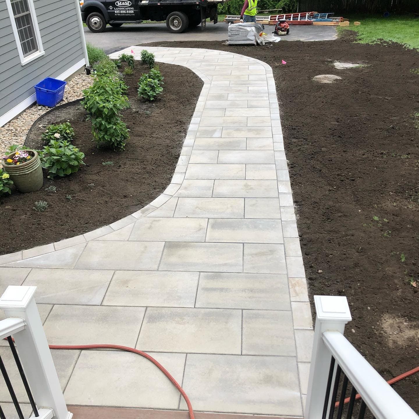 Light paver front walk curving up to porch steps