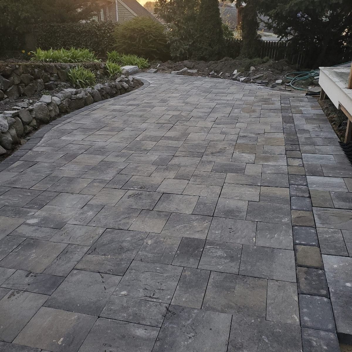 Wide paver walkway beside a stone wall