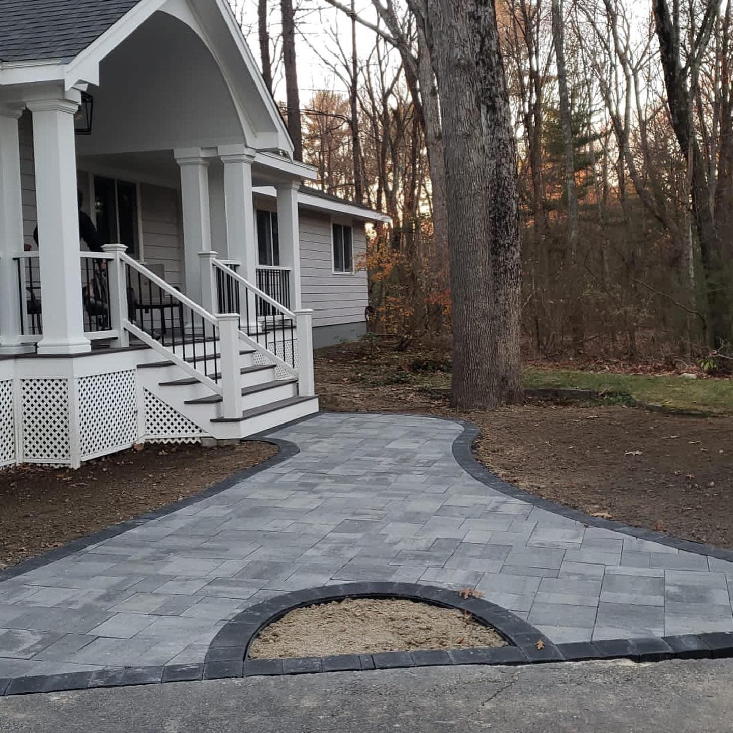 Paver walkway with a circular inlay leading to porch steps