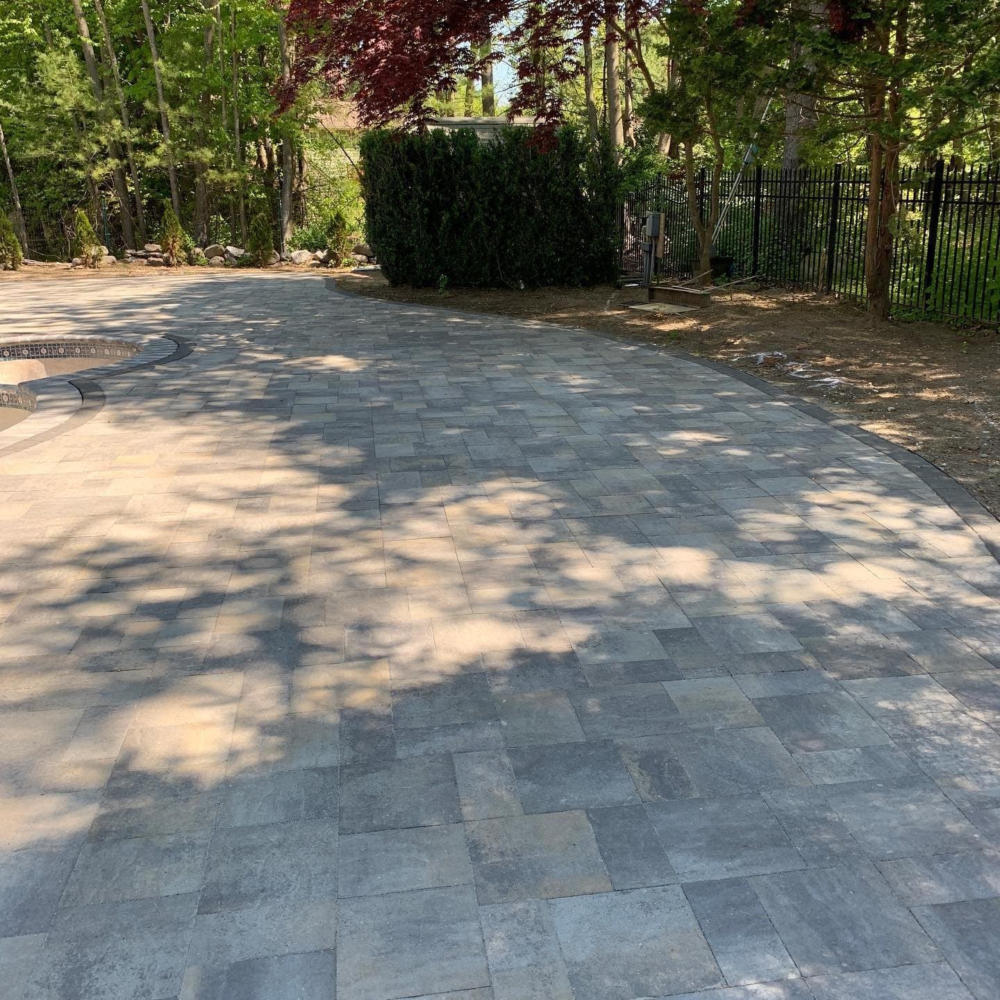Paver driveway curving past trees