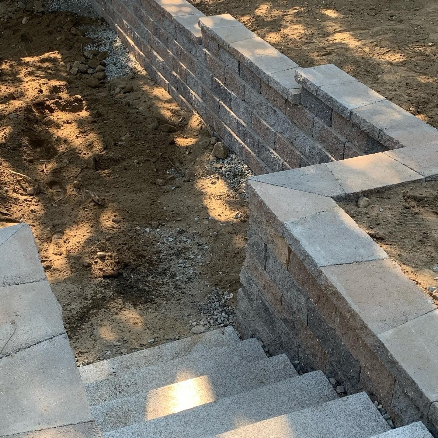 Block retaining wall and steps under construction with the footing visible