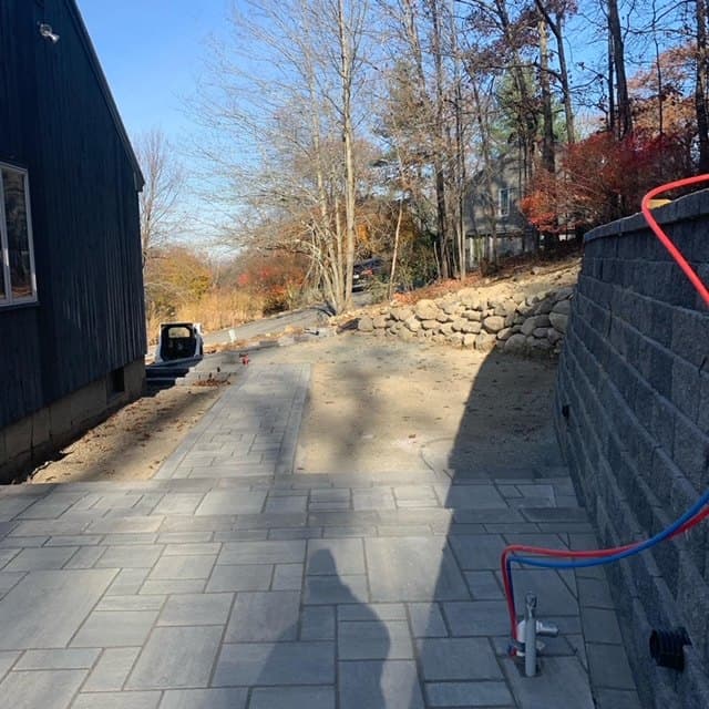 Tall block retaining wall along a paver walk