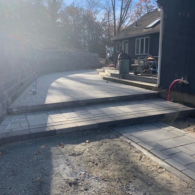 Block retaining wall along a long paver patio